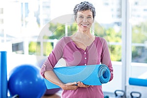 Portrait of mature woman with yoga mat