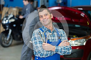portrait mechanic in garage holding tools