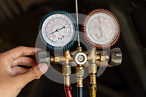 Portrait of a mechanic hand uses a pressure gauge to know a function of dynamo