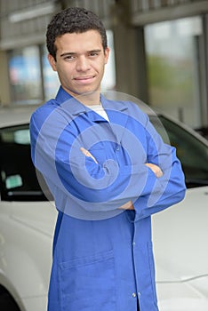 Portrait mechanic standing near car