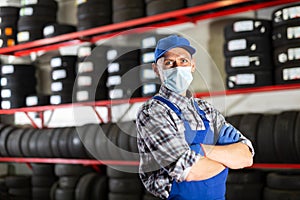 Portrait of mechanician in mask posing at auto service