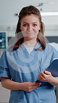 Portrait of medical assistant holding checkup documents