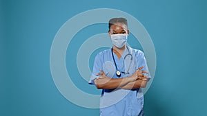 Portrait of medical assistant putting protective mask on face