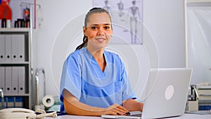 Portrait medical nurse in blue practitioner uniform smiling at camera