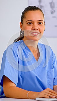 Portrait medical nurse in blue practitioner uniform smiling at camera