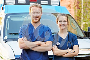 Portrait Of Medical Staff Standing In Front Of Ambulance photo