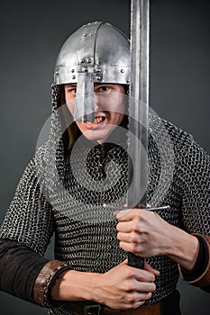 Portrait of a medieval warrior of the late Viking era and the beginning of the Crusades. Knight in chain mail and helmet photo