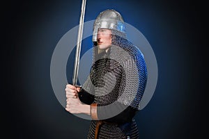 Portrait of a medieval warrior of the late Viking era and the beginning of the Crusades. Knight in chain mail and helmet photo