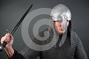 Portrait of a medieval warrior of the late Viking era and the beginning of the Crusades. Knight in chain mail and helmet photo