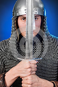Portrait of a medieval warrior of the late Viking era and the beginning of the Crusades. Knight in chain mail and helmet photo
