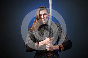 Portrait of a medieval warrior of the late Viking era and the beginning of the Crusades. Knight with long hair in chain mail