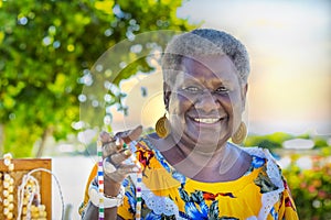 Portrait of a melanesian - australian mature woman smiling, outdoors.