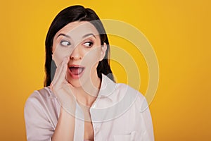 Portrait of messager girl palm open mouth talk look empty space on yellow background photo