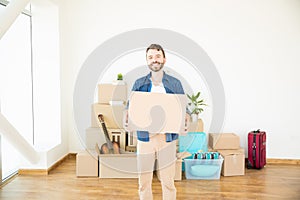 Householder With Corrugated Box Standing In New Home photo