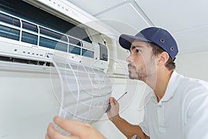 Portrait mid-adult male technician repairing air conditioner