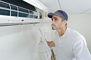 Portrait mid-adult male technician repairing air conditioner