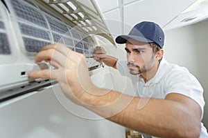 Portrait mid-adult male technician repairing air conditioner