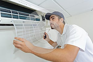 Portrait mid-adult male technician repairing air conditioner