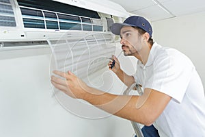 Portrait mid-adult male technician repairing air conditioner