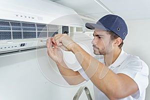 Portrait mid-adult male technician repairing air conditioner