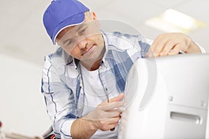 portrait mid-adult male technician repairing air conditioner