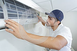 Portrait mid-adult male technician repairing air conditioner