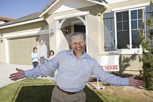 Portrait of mid-adult man in front of new house