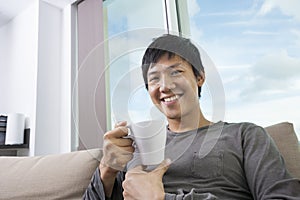 Portrait of mid adult man holding coffee cup in house