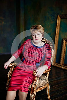 Portrait of mid-adult woman looking at camera sitting in armchair