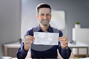 Smiling Businessman Holding Cheque photo