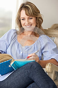 Portrait of mid age woman writing in notebook