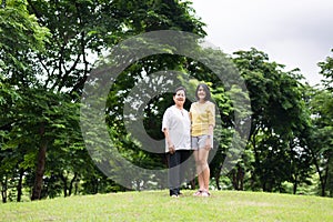 Portrait of middle aged asian woman with daughter standing at park together,Happy and smiling,Positive thinking,Take care and supp photo