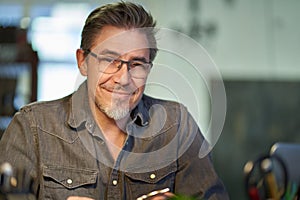 Portrait of middle aged bearded guy at home. maturee handsome man smiling, looking at camera, working at home, using laptop