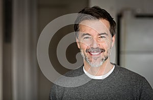 A portrait of a middle-aged bearded man smiling at the camera.