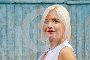 Portrait of a middle-aged beautiful cheerful woman on a wooden wall background. Success, antiaging