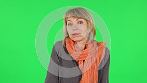 Portrait of middle aged blonde woman is saying oh my god and being shocked. Green screen