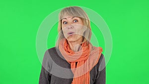 Portrait of middle aged blonde woman with shocked wow face expression. Green screen