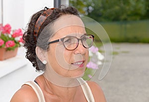 Portrait of a middle-aged brunette woman with eyeglasses, outdoor