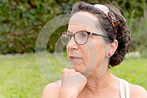 Portrait of a middle-aged brunette woman with eyeglasses, outdoor