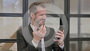 Portrait of Middle Aged Businessman Celebrating Success on Phone