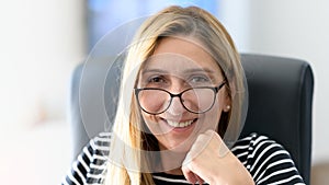 Portrait of a middle aged businesswoman sitting in the office and smiling happily