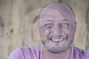 Portrait of middle-aged caucasian bald man looking straight at camera, close up