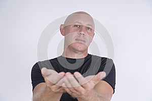 Portrait of middle-aged caucasian bald man looking straight at camera, close up