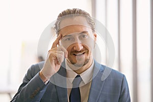 Portrait of middle-aged Caucasian businessman sitting at the office Smile and looking toward camera with enlighten expression in