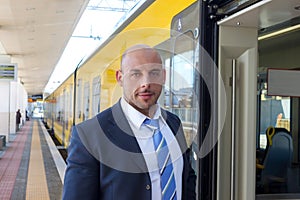 The train conductor on the platform next to the train