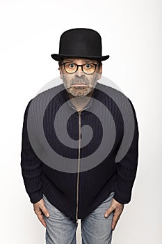 Portrait middle-aged man with glasses, bowler hat and round glasses, is leaning forward