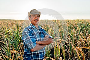 Portrait of middle aged man with hat, standing arms crossed and looking at camera, photo