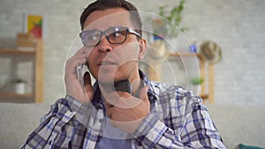 Portrait of middle-aged man in home answering a phone call uses Speech Aid problems with ligaments