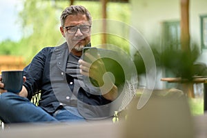 Portrait of middle aged man at home relaxing in garden