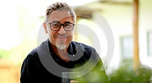 Portrait of middle aged man at home relaxing in garden